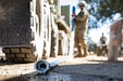 U.S. Army Reserve Spc. Bryan Dakota, a water treatment specialist with the 651st Quartermaster Company rolls a hose after refilling a water bag during Combat Support Training Exercise 91-22-01 at Fort Hunter Liggett, California, June 15. The water filtering into the bags is pumped out of Coleman Reservoir and purified to be potable for Army Reserve Soldiers attending the exercise. (U.S. Army Reserve photo by Sgt. Jeremiah Woods)