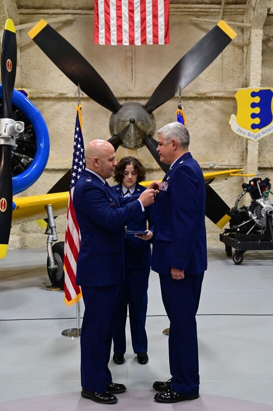 Col. Joseph Sheffield, the 28th Bomb Wing commander, presents the Meritorious Service Medal to Lt. Col. Kenneth Byrd, the 28th Comptroller Squadron outgoing commander, during the 28th Comptroller Squadron Change of Command Ceremony at Ellsworth Air Force Base, S.D., June 24, 2022.