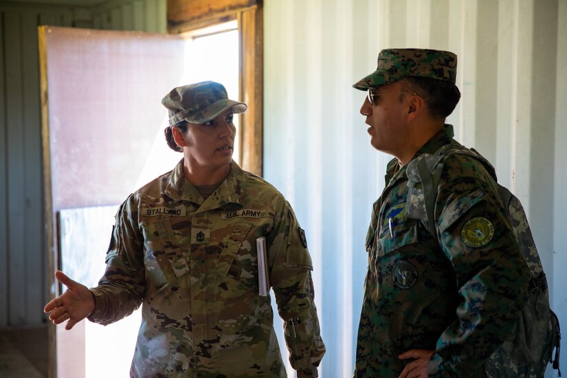 Kentucky Army National Guard's 1st Sgt. Naarah Stallard, NCOIC and translator with Kentucky's State Partnership Program, explains the use of one of the urban training sites to servicemembers from Ecuador at Wendell H. Ford Regional Training Center in Greenville, Ky. on June 29, 2022. Ecuadorian enlisted servicemembers visited the 238th RTI to exchange instructor techniques and procedures in part of the State Partnership Program. (U.S. Army photo by Andy Dickson)