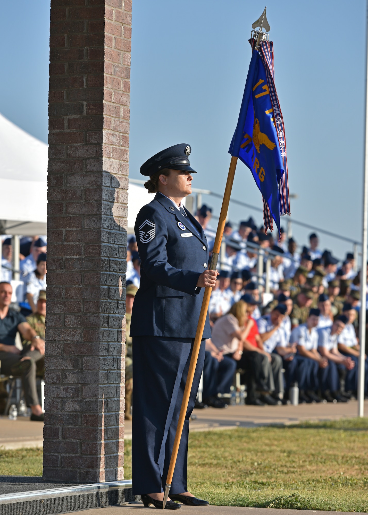 U.S. Air Force Senior Master Sgt. Heather Celano, 17th Training Group acting command chief, holds the guidon during the 17th TRG change of command at Goodfellow Air Force Base, Texas, June 30, 2022. The passing of the guidon represents the command transferring from the outgoing commander to the incoming commander. (U.S. Air Force photo by Senior Airman Ashley Thrash)