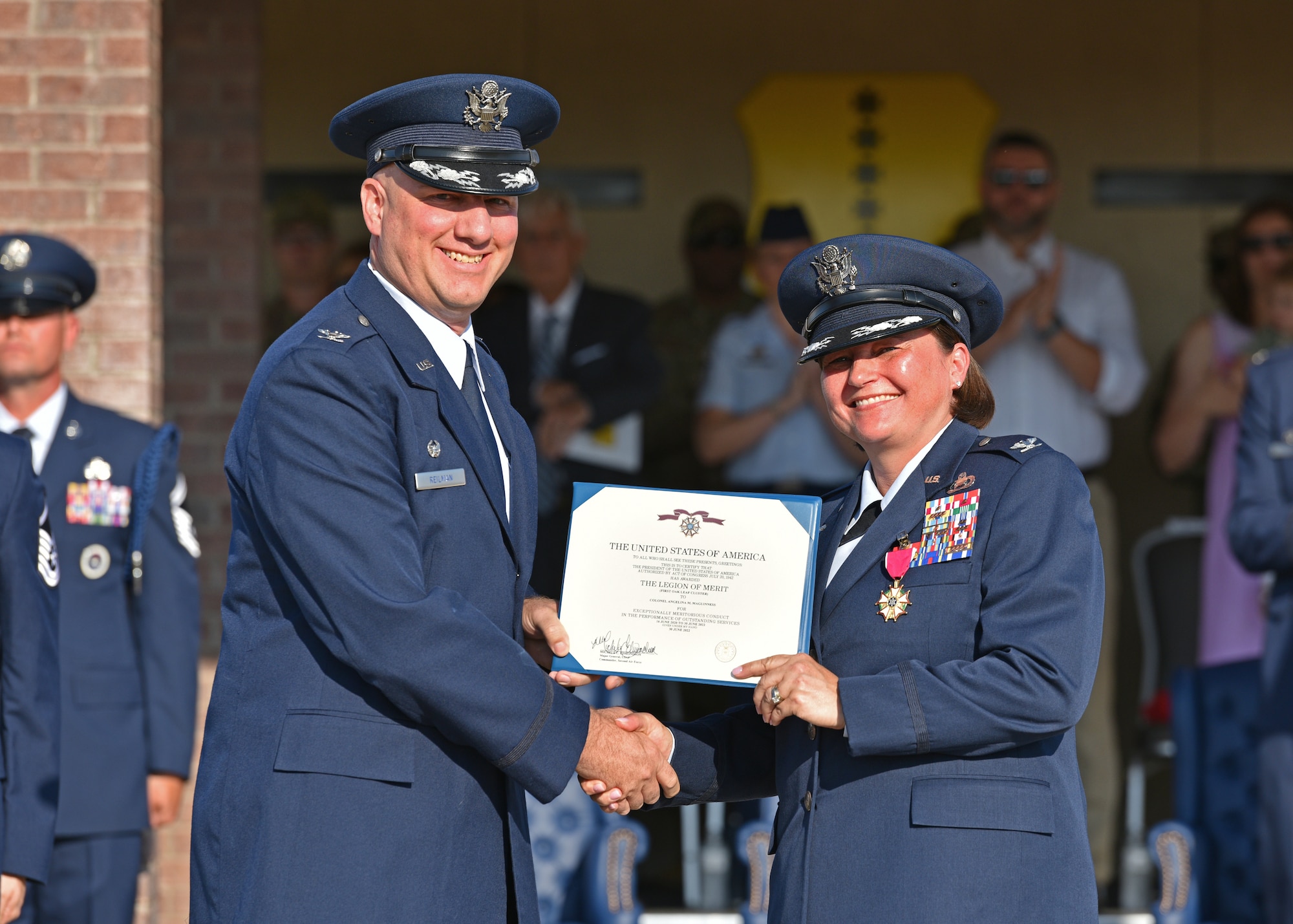 U.S. Air Force Col. Matthew Reilman, 17th Training Wing commander, presents a decoration to Col. Angelina Maguinness, right, outgoing 17th Training Group commander, during the 17th TRG change of command at Goodfellow Air Force Base, Texas, June 30, 2022. Maguinness was highlighted for her outstanding leadership of the 17th TRG during her two years in command.  (U.S. Air Force photo by Senior Airman Ashley Thrash)