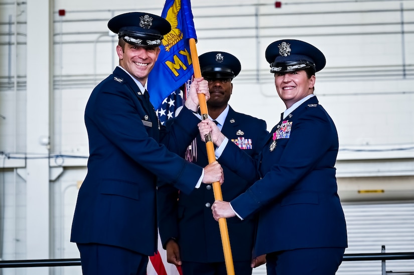 U.S. Air Force Col. Scott Wiederholt, 305th Air Mobility Wing commander, takes the flag from U.S. Air Force Col. Mary Teeter, 305th Maintenance Group commander, as she relinquishes commands at Joint Base McGuire-Dix-Lakehurst, N.J., June 30, 2022. Teeter relinquished command to U.S. Air Force Col. Scott Pendley after having led CAN DO Airmen during the COVID-19 pandemic and Operations Allies Welcome/Refuge.