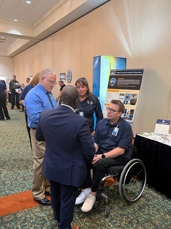 IMAGE: A recruiter with the Naval Surface Warfare Center Dahlgren Division (NSWCDD) discusses job opportunities with a candidate at the NSWCDD-sponsored Career Fair June 27 at the Fredericksburg Expo and Conference Center.