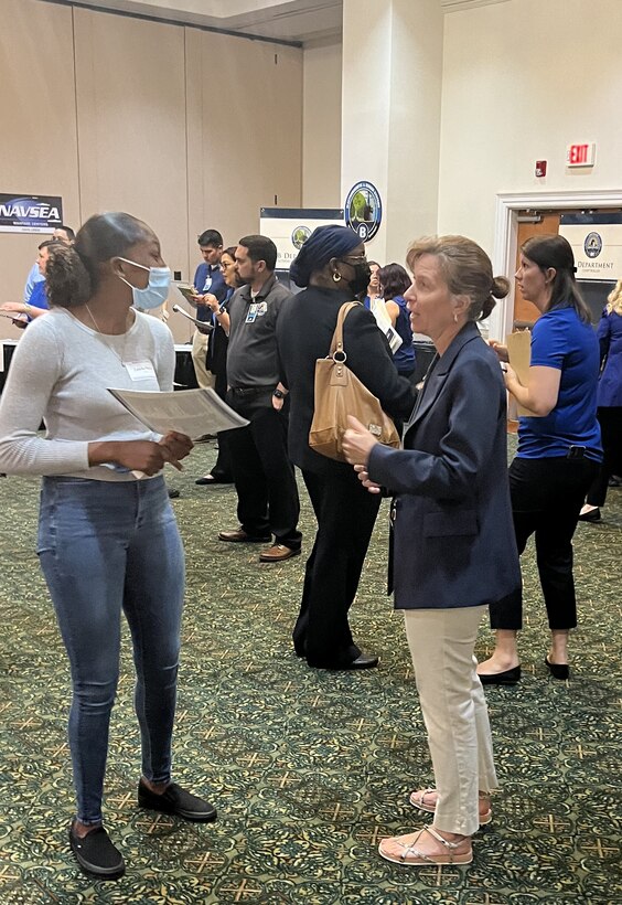 IMAGE: A recruiter with the Naval Surface Warfare Center Dahlgren Division (NSWCDD) discusses job opportunities with a candidate at the NSWCDD-sponsored Career Fair June 27 at the Fredericksburg Expo and Conference Center.