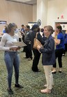 IMAGE: A recruiter with the Naval Surface Warfare Center Dahlgren Division (NSWCDD) discusses job opportunities with a candidate at the NSWCDD-sponsored Career Fair June 27 at the Fredericksburg Expo and Conference Center.