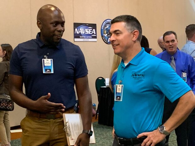 IMAGE: Naval Surface Warfare Center Dahlgren Division (NSWCDD) Technical Director Dale Sisson, SES, talks with Joe Brickhouse from the Integrated Combat System Department at the NSWCDD Job Fair on June 27.