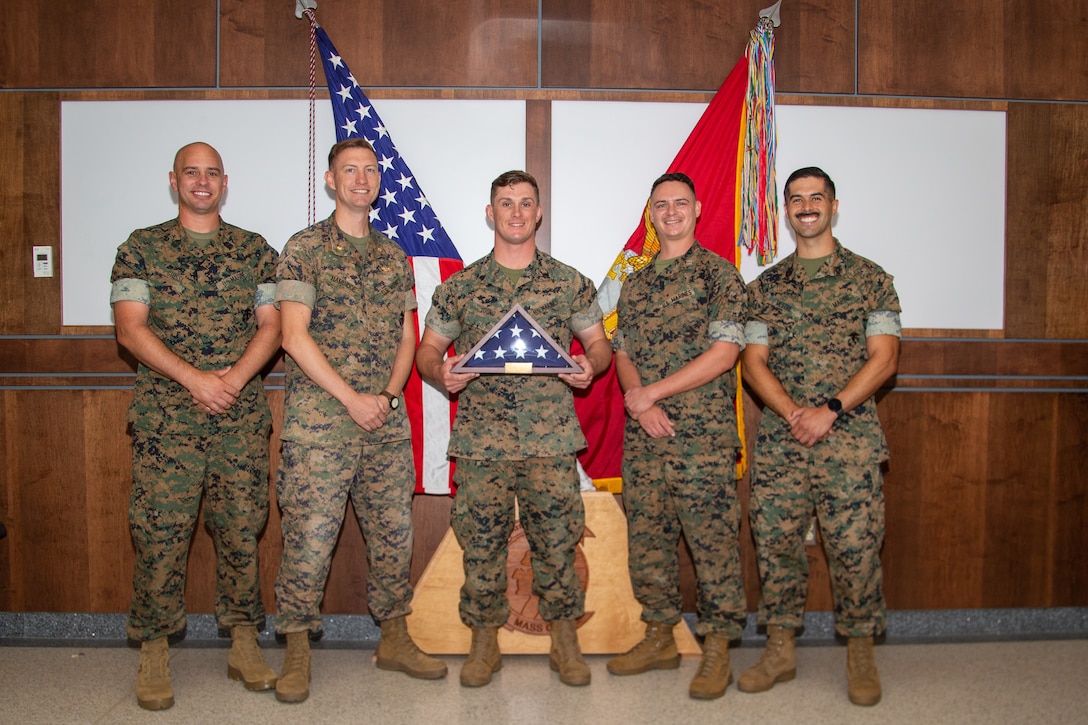 U.S. Marine Corps Sgt. Phillip Young, a tactical data systems technician with Marine Air Control Group 28, 2nd Marine Aircraft Wing (center), stands with his unit  leaders at Marine Corps Air Station Cherry Point, North Carolina, June 24, 2022. Young was recognized as the Service Person of the Quarter by the Carteret County Chamber of Commerce Military Affairs Committee for his dedication to giving back to the local community. (U.S. Marine Corps photo by Lance Cpl. Lauralle Walker)