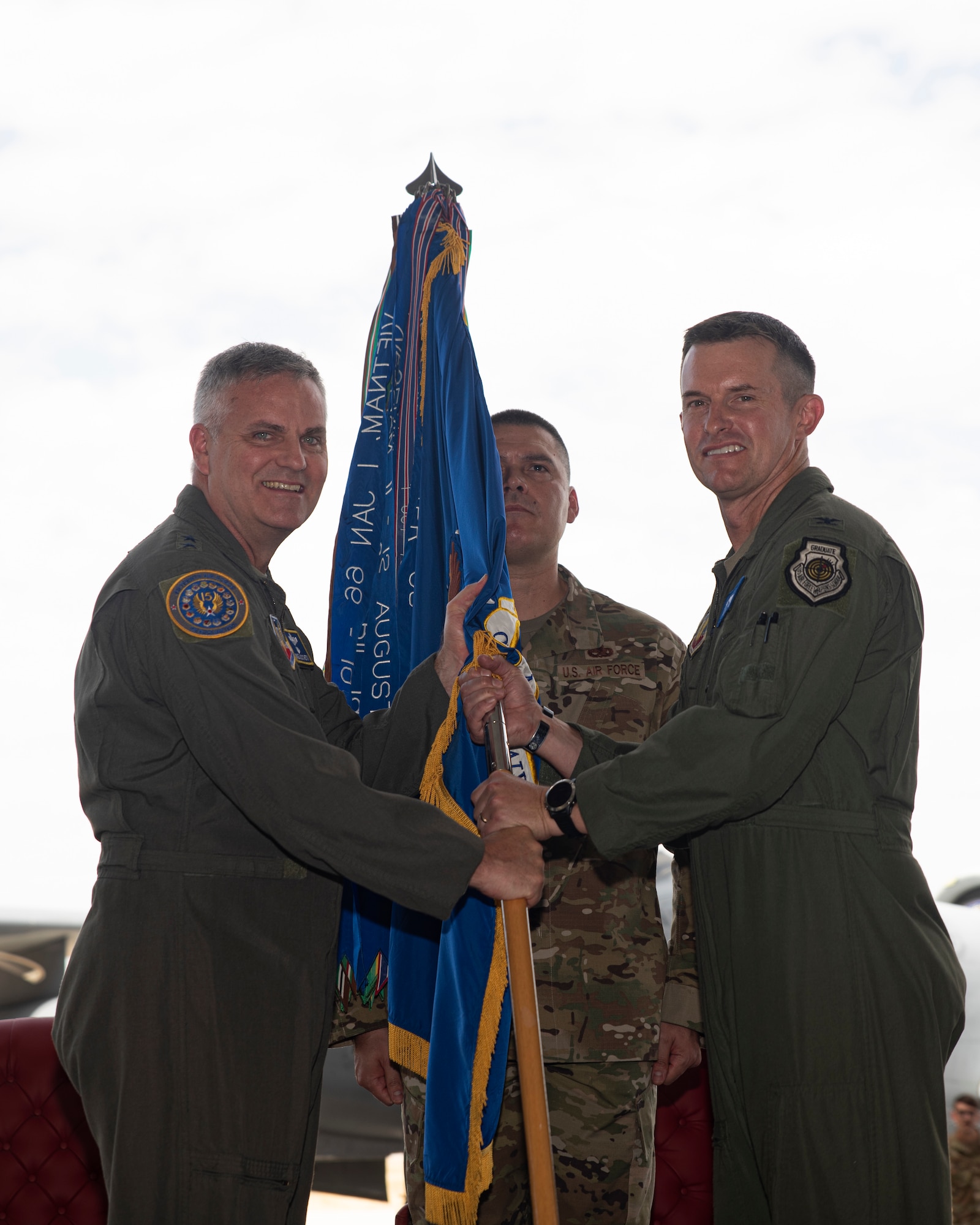 A photo of two Airmen holding onto a flag