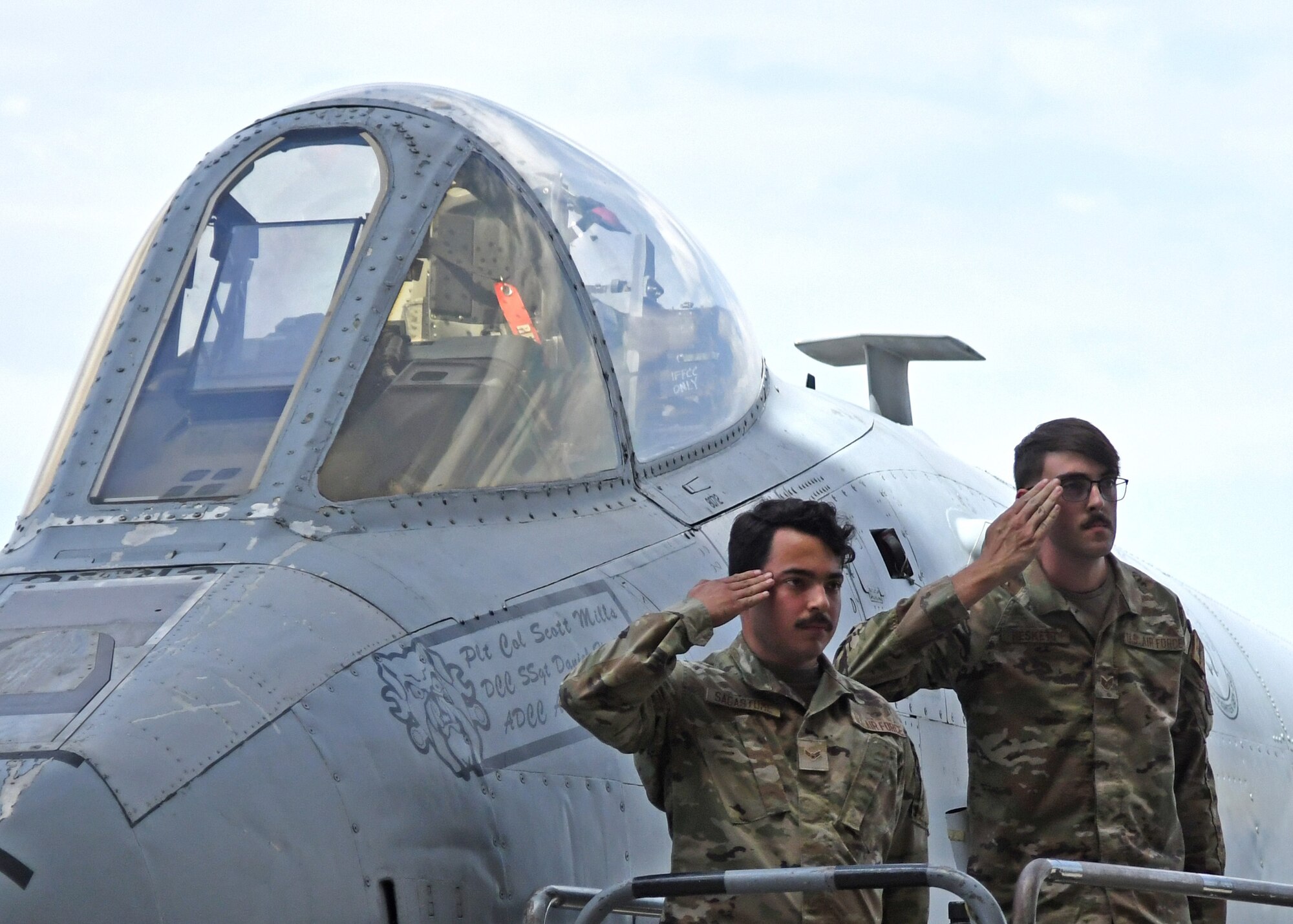 A photo of two people saluting.