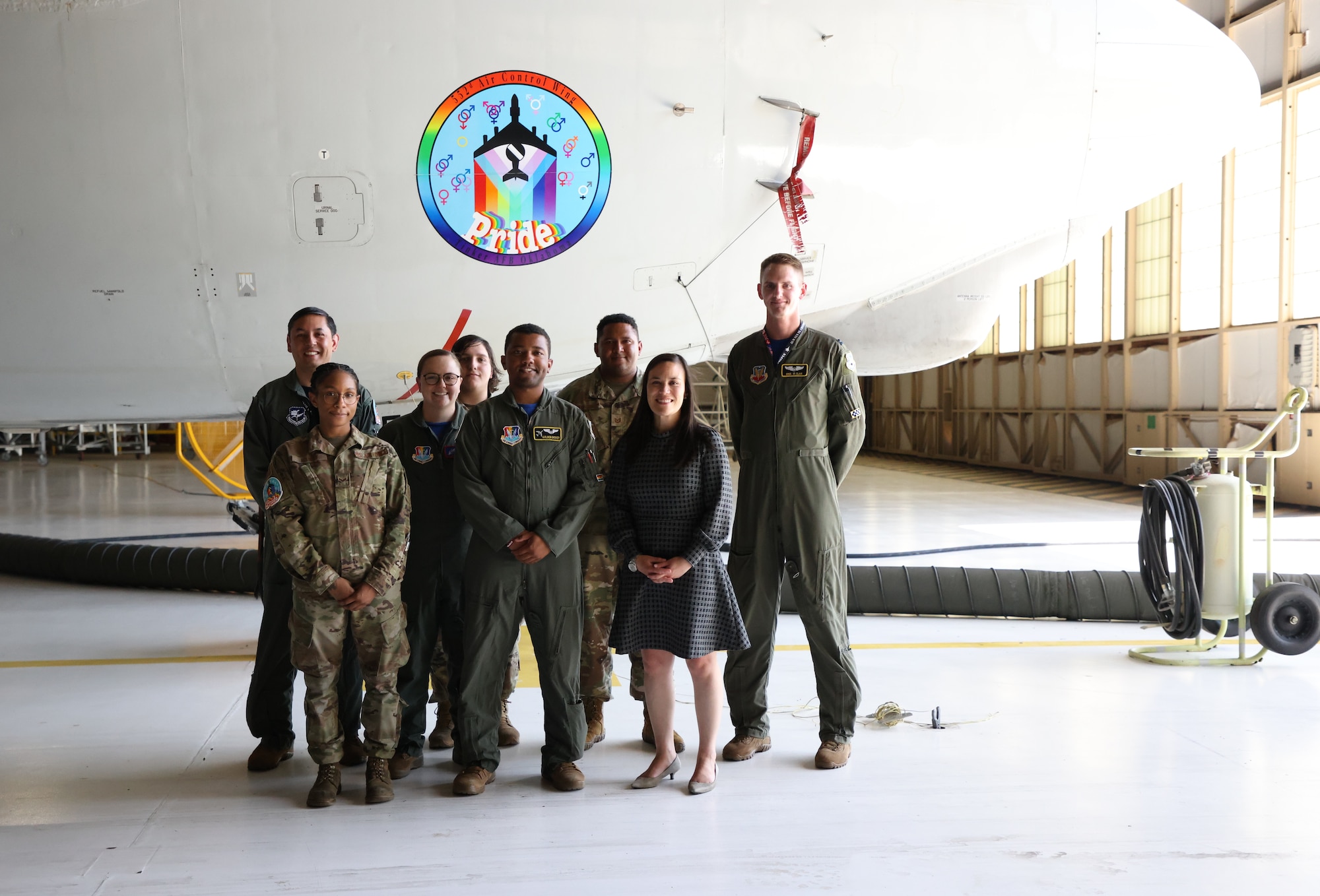 Group of Airmen with Under Secretary of the Air Force pose in front of E-3 Sentry aircraft.