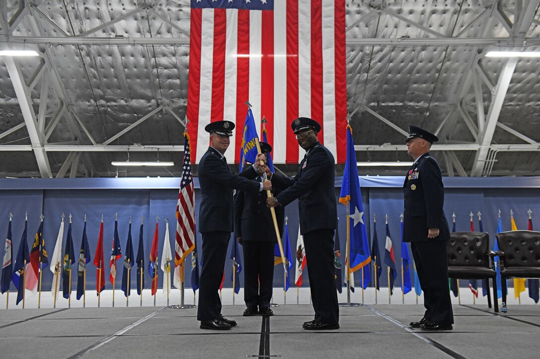Col. Todd Randolph takes the guidon from Maj. Gen. Joel Jackson as he assumes command of the 316th Wing and the installation in Hanger 3 at Joint Base Andrews, Md., June 30, 2022.