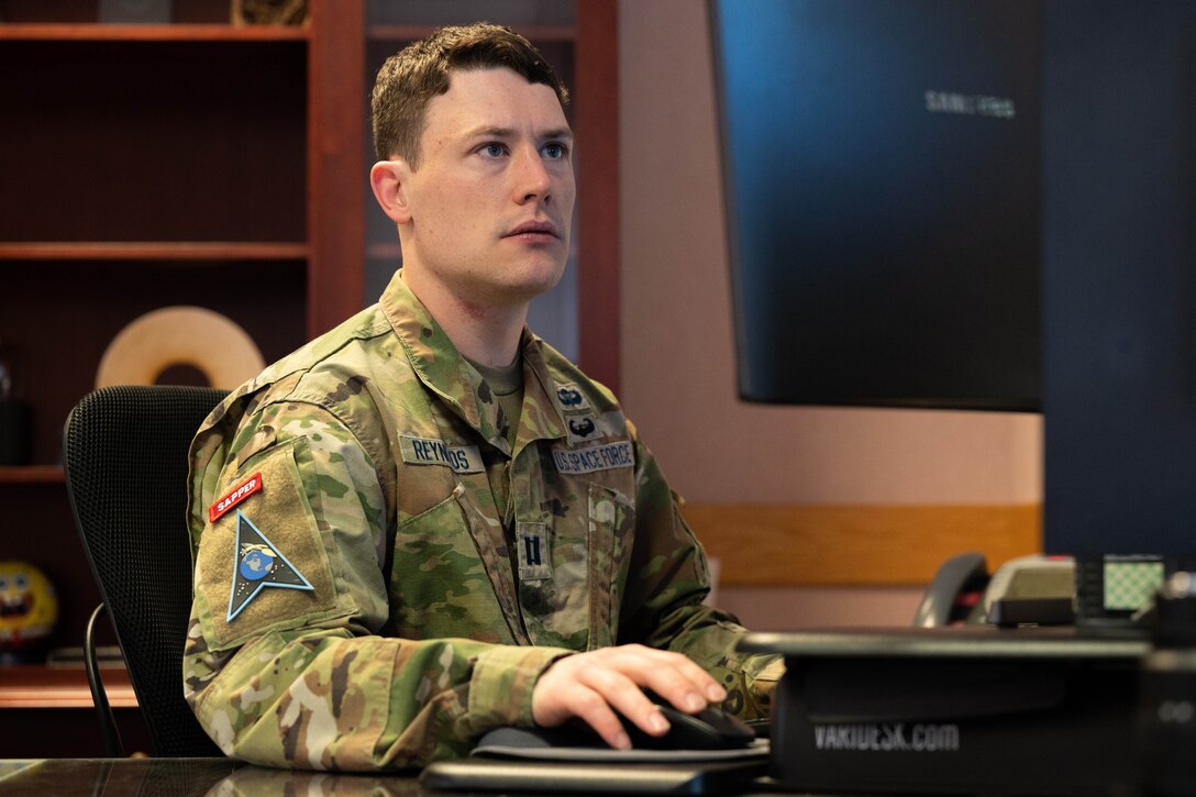 A guardian sits at a computer.