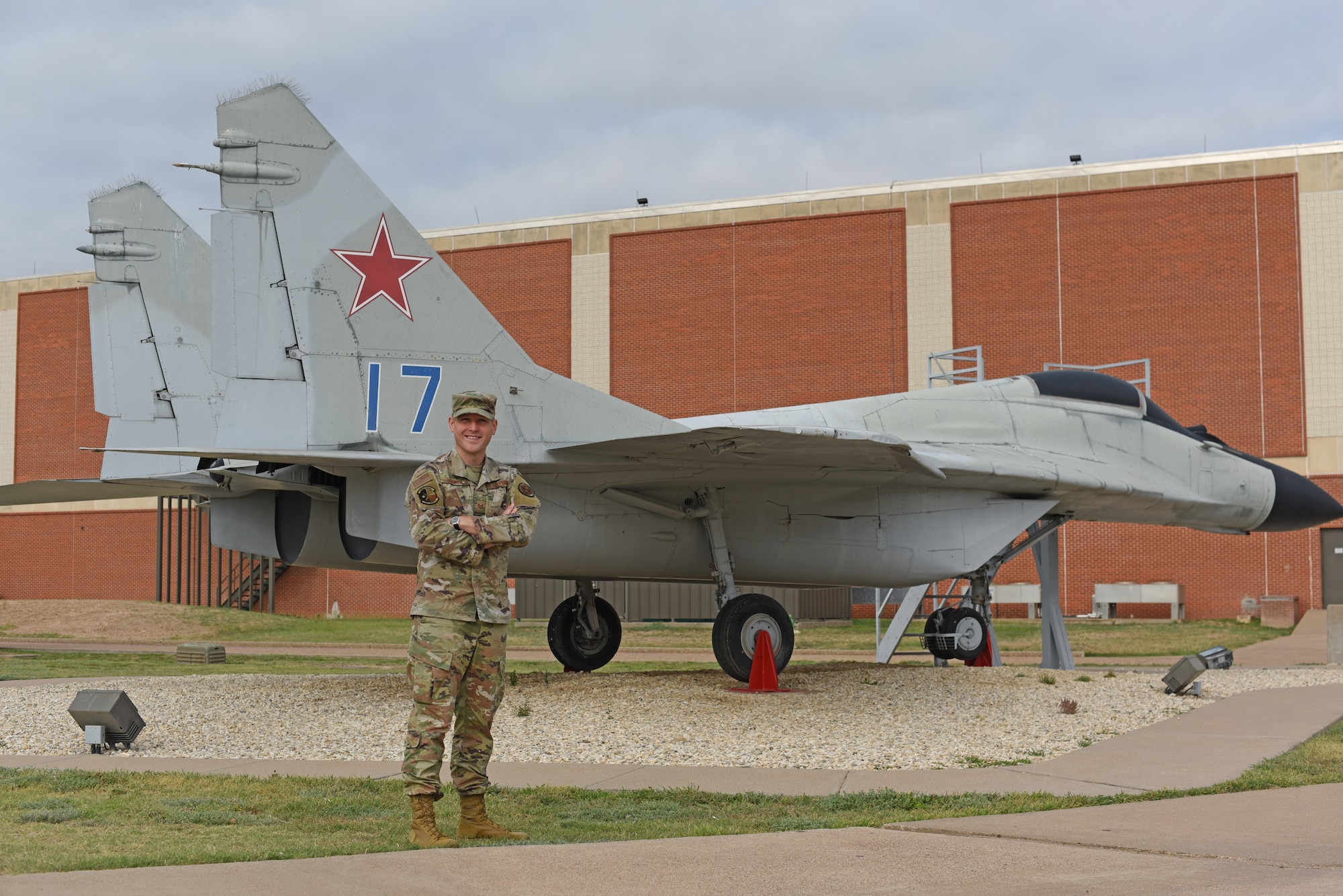 U.S. Air Force Tech. Sgt. Dylan Hudson, 316th Training Squadron apprentice signals collection course noncommissioned officer in charge, poses for a photo at the MiG-29 static display, Goodfellow Air Force Base, Texas, June 27, 2022. The MiG-29 is a Soviet era twin-engine fighter aircraft and is used as a static display to enhance training on base. (U.S. Air Force photo Airman 1st Class Zachary Heimbuch
