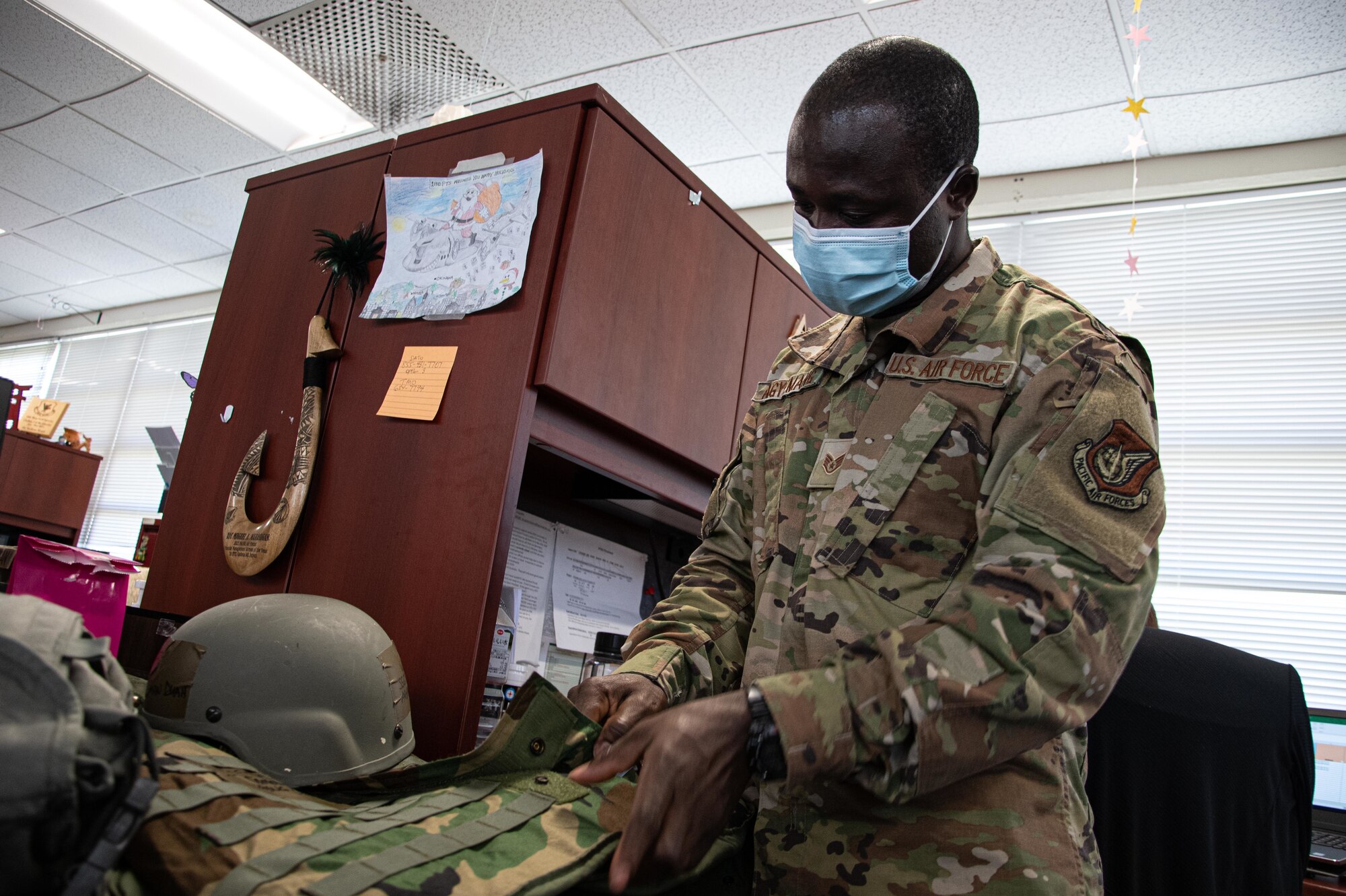Photo of airman inspecting protective equipment.