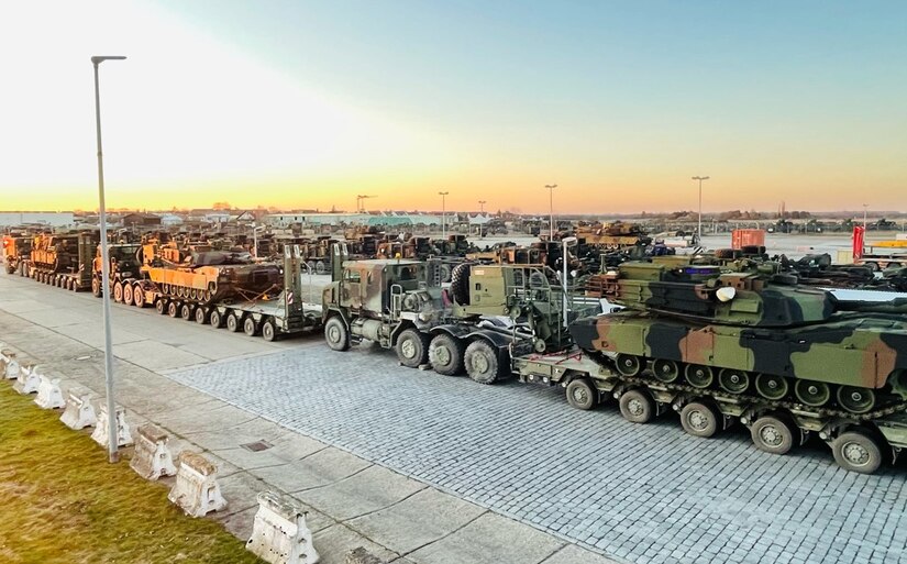 A line of military Heavy Equipment Transport line-haul trucks is staged at Coleman work site in Mannheim, Germany. Each truck is hauling equipment and vehicles, such as M1 Abrams main battle tanks as seen here, to Grafenwoehr Training Area in Germany. There, the vehicles and equipment pieces will be issued to the 1st Armored Brigade Combat Team, 3rd Infantry Division deploying to Germany from Fort Stewart, Georgia. (U.S. Army Photo by Maj. Allan Laggui)