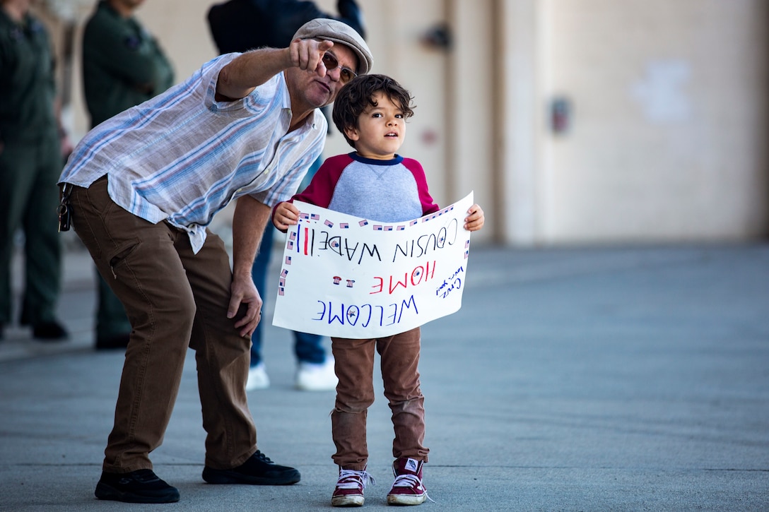 Family members await the arrival of U.S. Marines and Sailors with Marine Medium Tiltrotor Squadron (VMM) 165 (Reinforced), 11th Marine Expeditionary Unit, during a homecoming on Marine Corps Air Station Camp Pendleton, California, Feb. 28, 2022.  The squadron returned from the unit’s Western Pacific 21.2 deployment in support of U.S. 3rd, 5th, and 7th Fleet area of operations as part of the Essex Amphibious Ready Group. 



(U.S. Marine Corps photo by Sgt. Dana Beesley)