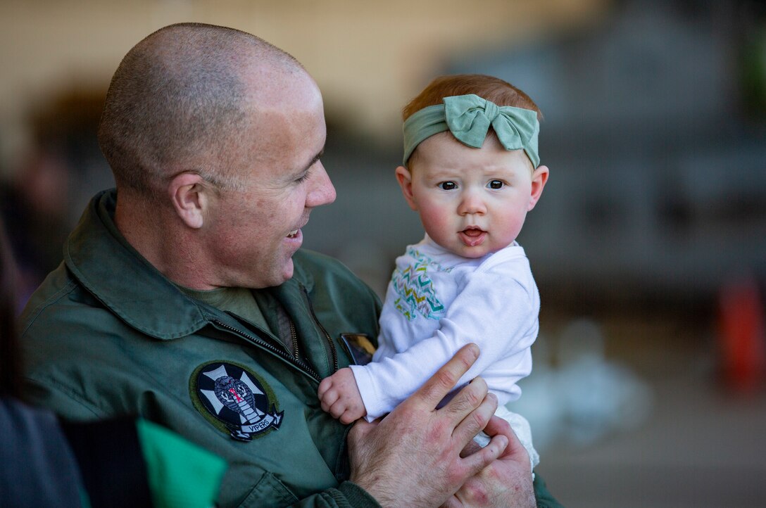 A U.S. Marine attached to Marine Medium Tiltrotor Squadron (VMM) 165 (Reinforced), 11th Marine Expeditionary Unit, shares a moment with his daughter during a homecoming on Marine Corps Air Station Camp Pendleton, California, Feb. 28, 2022.  The squadron returned from the unit’s Western Pacific 21.2 deployment in support of U.S. 3rd, 5th, and 7th Fleet area of operations as part of the Essex Amphibious Ready Group. 



(U.S. Marine Corps photo by Sgt. Dana Beesley)