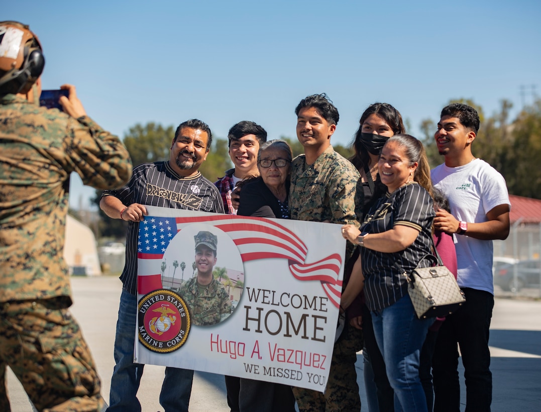 U.S. Marine Corps Cpl., Marine Medium Tiltrotor Squadron (VMM) 165 (Reinforced), 11th Marine Expeditionary Unit, and his family pose for a group photo during a homecoming on Marine Corps Air Station Camp Pendleton, California, Feb. 28, 2022.  The squadron returned from the unit’s Western Pacific 21.2 deployment in support of U.S. 3rd, 5th, and 7th Fleet area of operations as part of the Essex Amphibious Ready Group. 



(U.S. Marine Corps photo by Sgt. Dana Beesley)