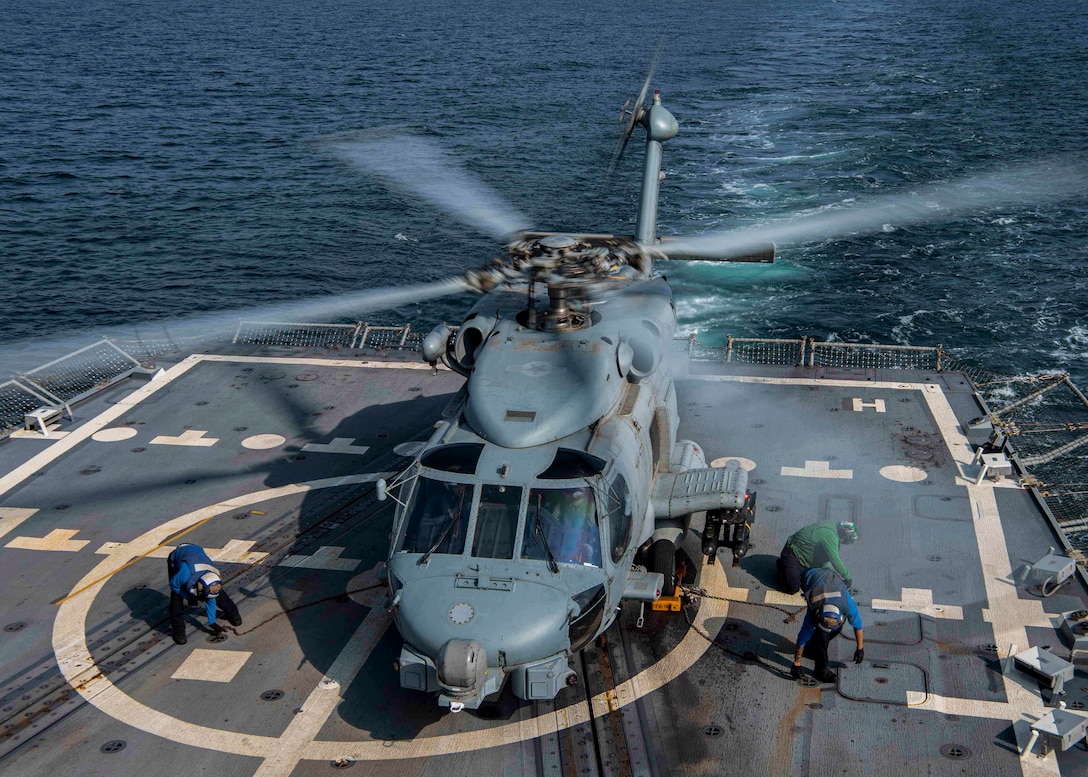 GULF OF OMAN (Feb. 28, 2022) Sailors assigned to the guided-missile destroyer USS Gridley (DDG 101), chock and chain an MH-60R Sea Hawk helicopter, attached to the “Raptors” of Helicopter Maritime Strike Squadron (HSM) 71, at the conclusion of flight operations in the Gulf of Oman, Feb. 28. Gridley is deployed to the U.S. 5th Fleet area of operations in support of naval operations to ensure maritime stability and security in the Central Region, connecting the Mediterranean and Pacific through the Western Indian Ocean and three strategic choke points. (U.S. Navy photo by Mass Communication Specialist 2nd Class Colby A. Mothershead)