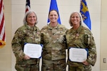 U.S. Air Force Senior Master Sgt. Tammy Mundy and Chief Master Sgt. Tabatha King pose for a portrait with Lt. Col. Rebecca Rudy after their combined retirement ceremony Feb. 5, 2022, at the 178th Wing in Springfield, Ohio. Mundy and King are identical twins who have served side-by-side their entire military careers.