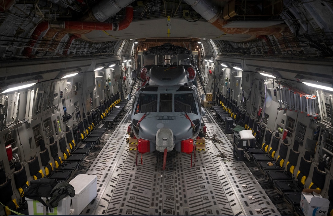 A helicopter sits inside fixed-wing aircraft.
