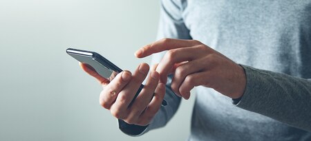 Hands holding a cell phone.