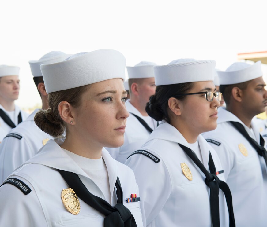 Sailors standing in formation in white uniform waiting for inspection
