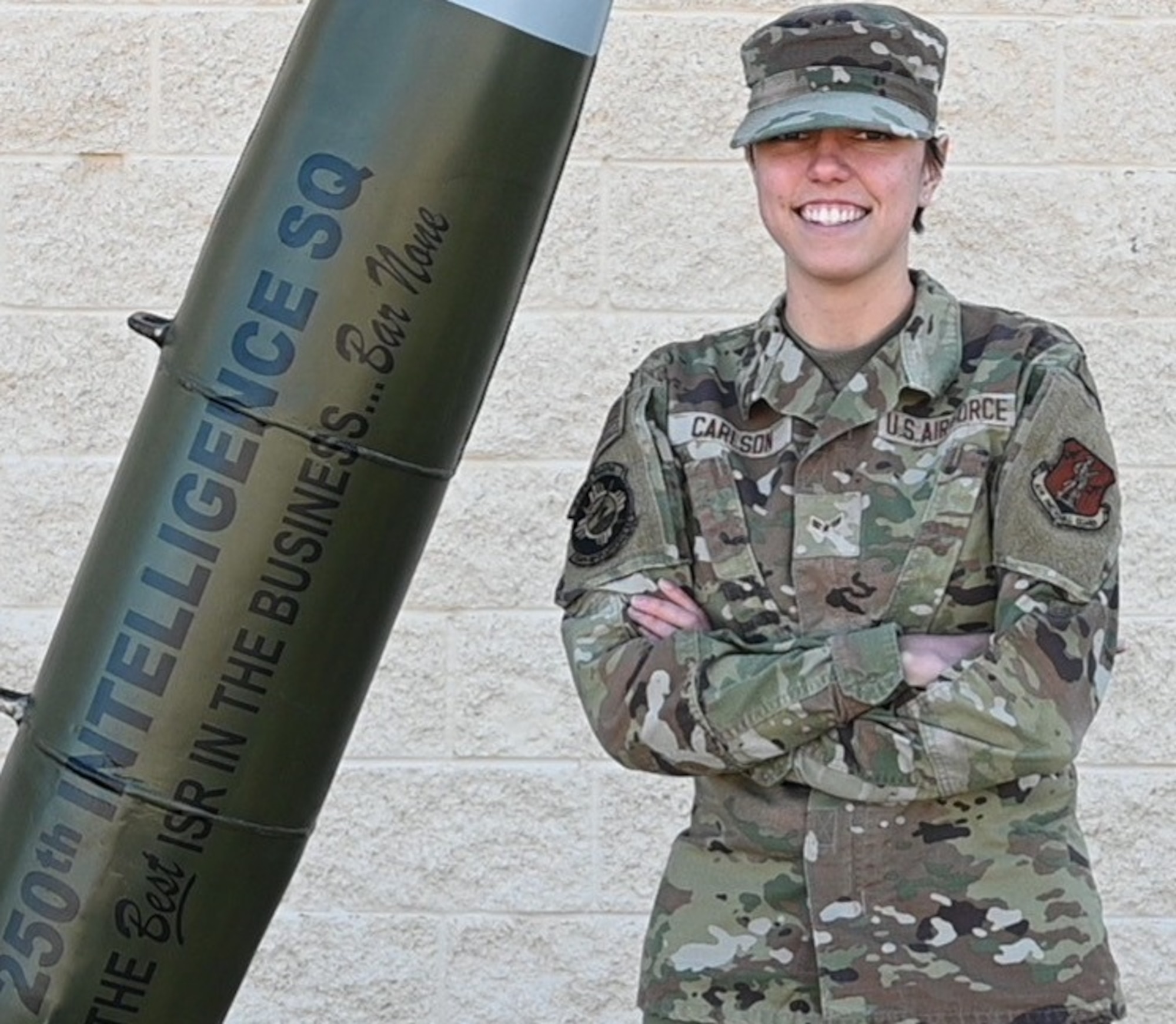 A woman in an Air Force uniform is posing in front of a building.