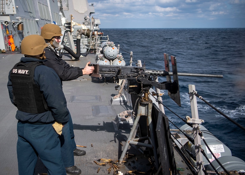 Sailors operate a gun.