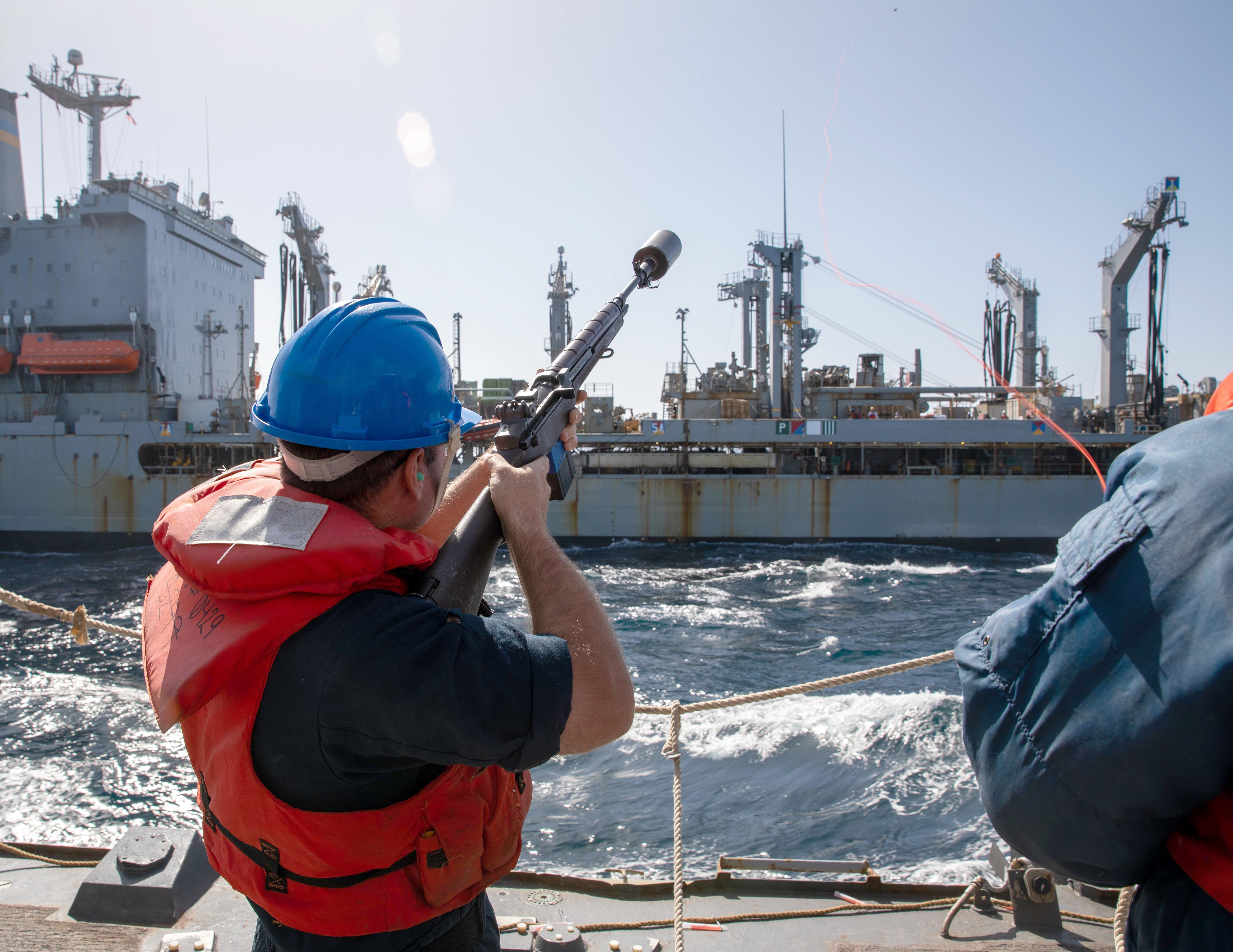 Gunner's Mate Seaman Michael Chandler fires a shot line to the fleet replenishment oiler USNS Patuxent (T-AO 201) from aboard the Arleigh Burke-class guided-missile destroyer USS Roosevelt (DDG 80).