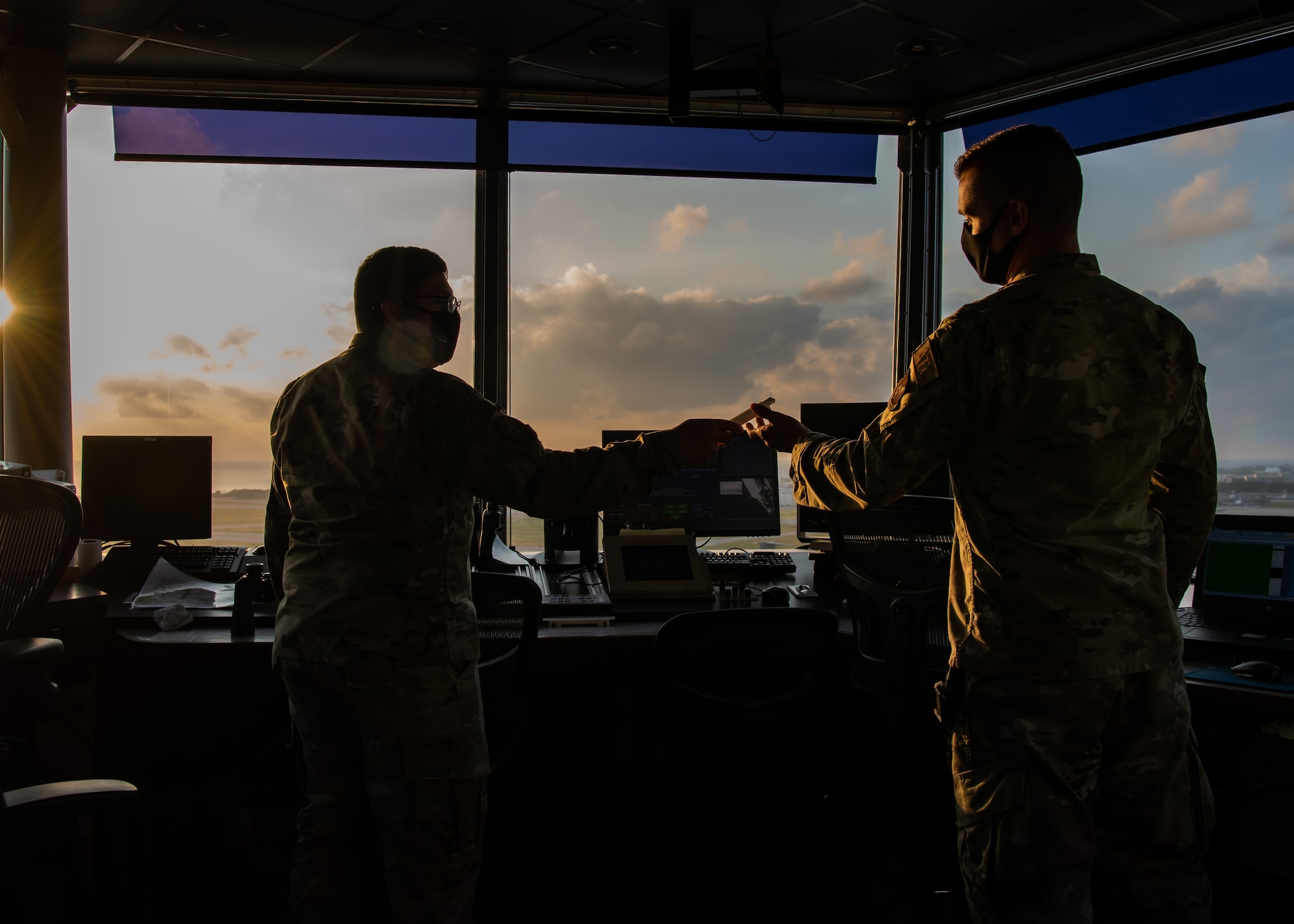 An Airman hands something to another Airman.