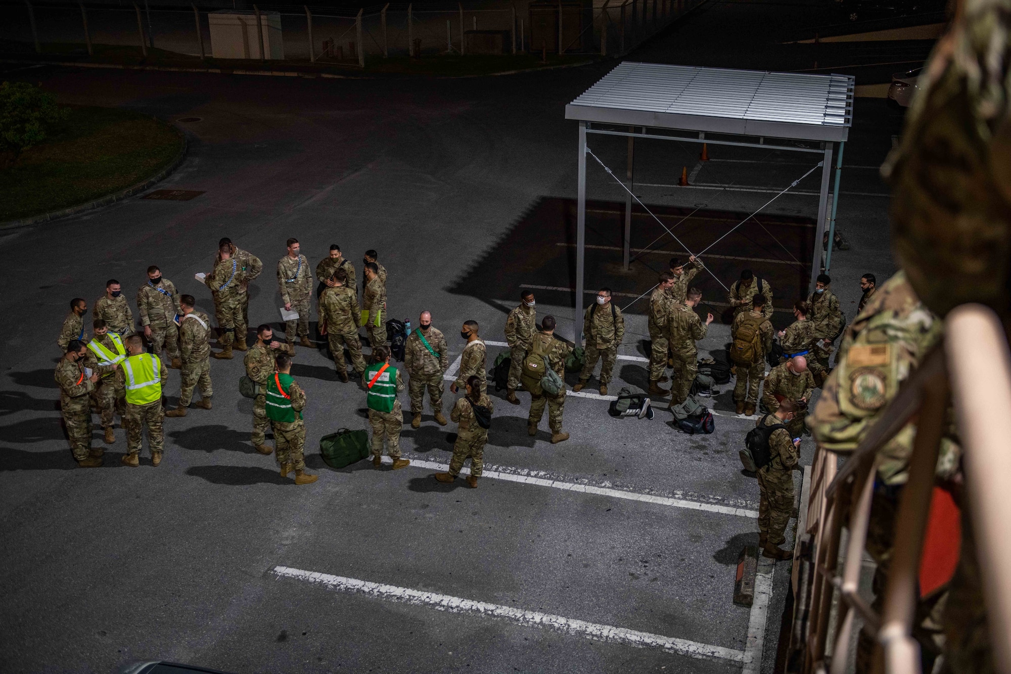 A group of Airmen wait in a parking lot