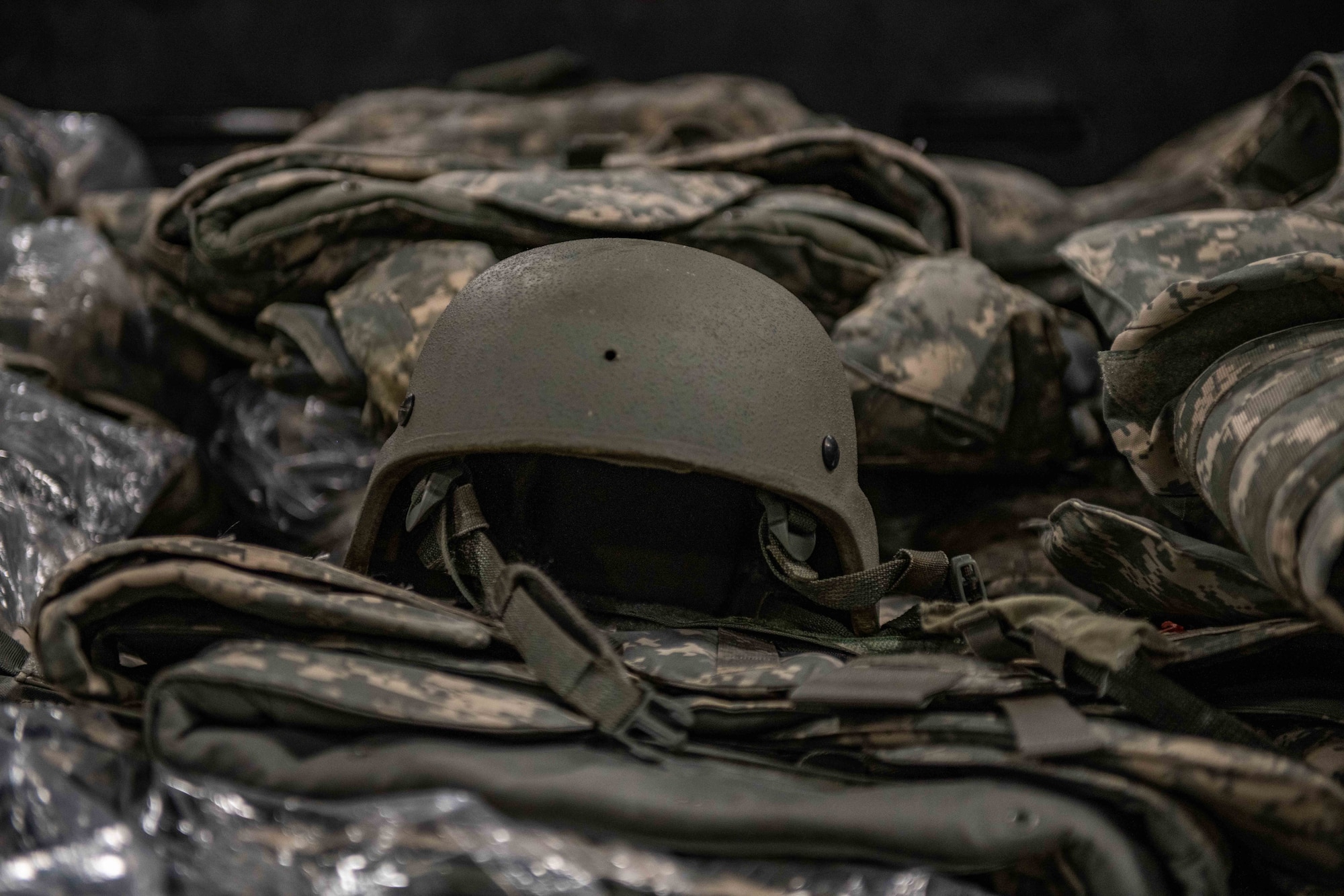 A helmet lies on top of a bin of vests