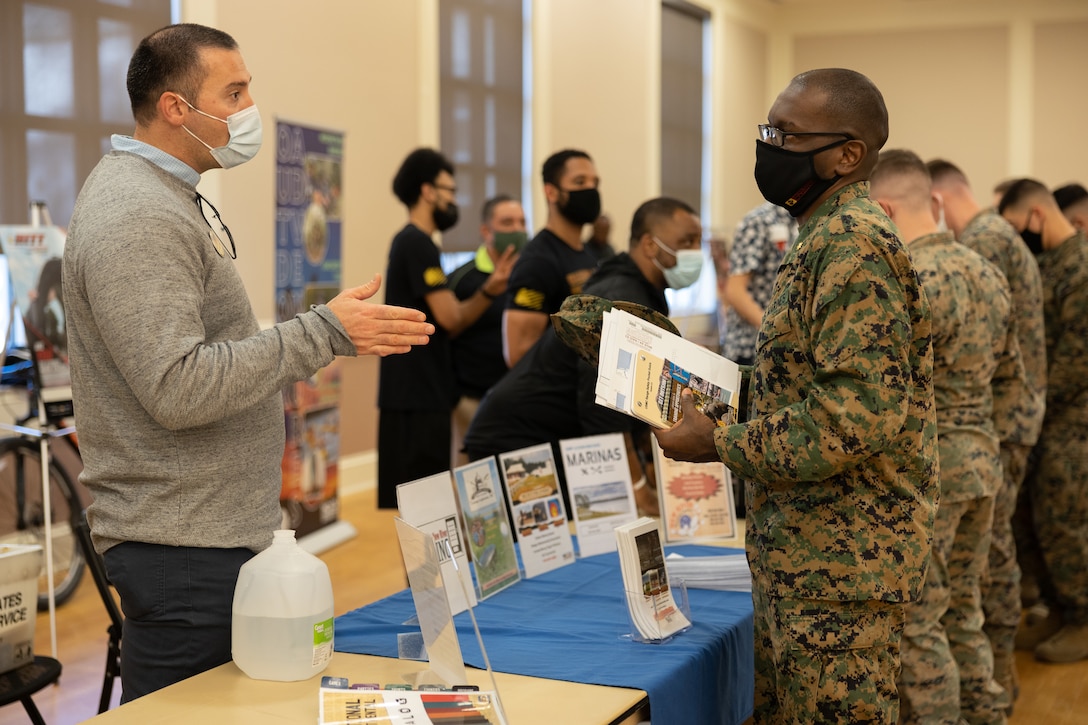 Patrick Larkin, left, director of services, MCCS Lejeune-New River, speaks with U.S. Marine Corps Maj. Lamont Robinson, executive officer with 2d Supply Battalion during the Warfighter Training Symposium at Marston Pavilion on Marine Corps Base Camp Lejeune, North Carolina, Feb. 28, 2022.