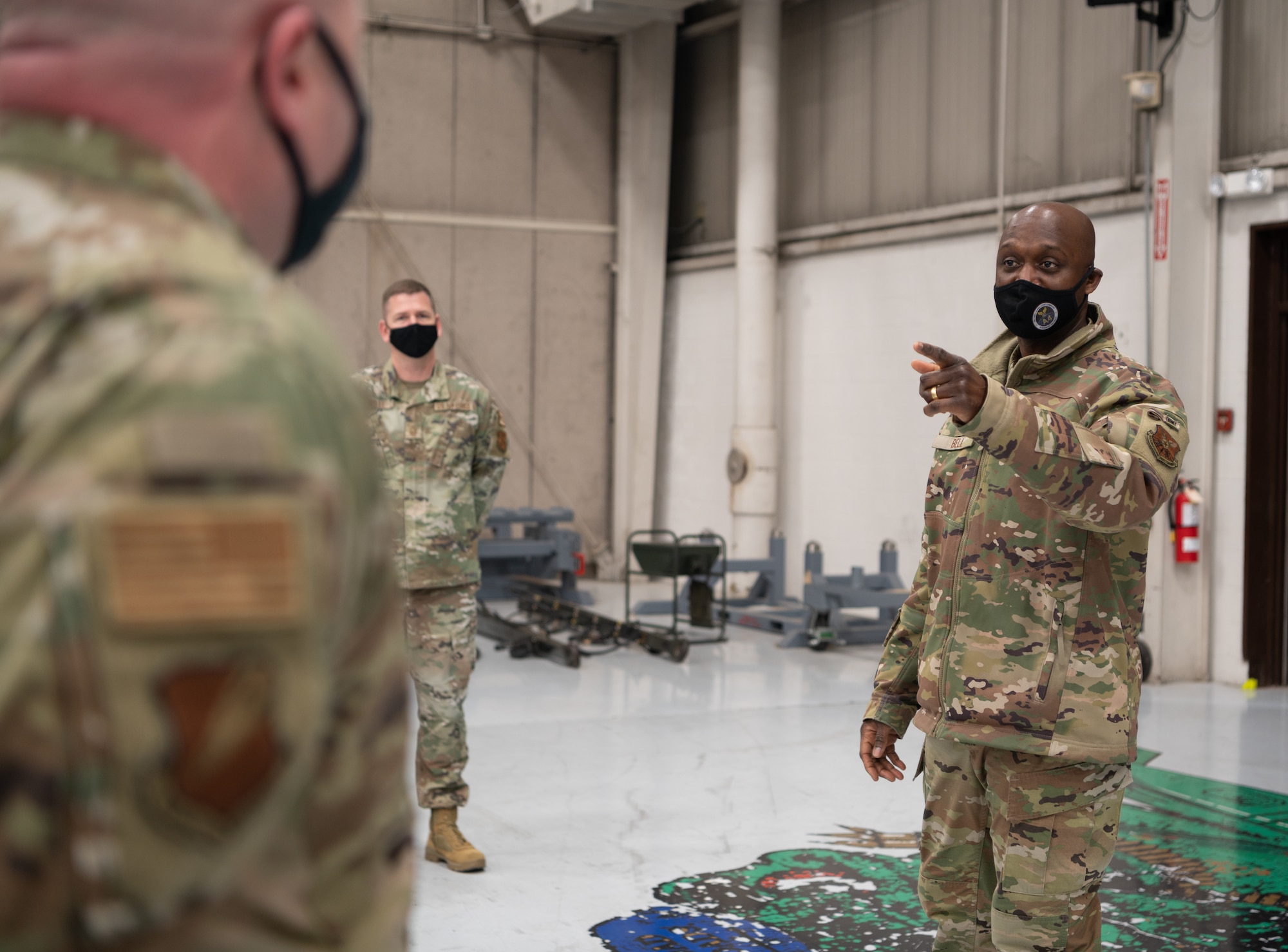 Brig. Gen. Kenyon Bell speaks with weapons Airmen standing in formation.