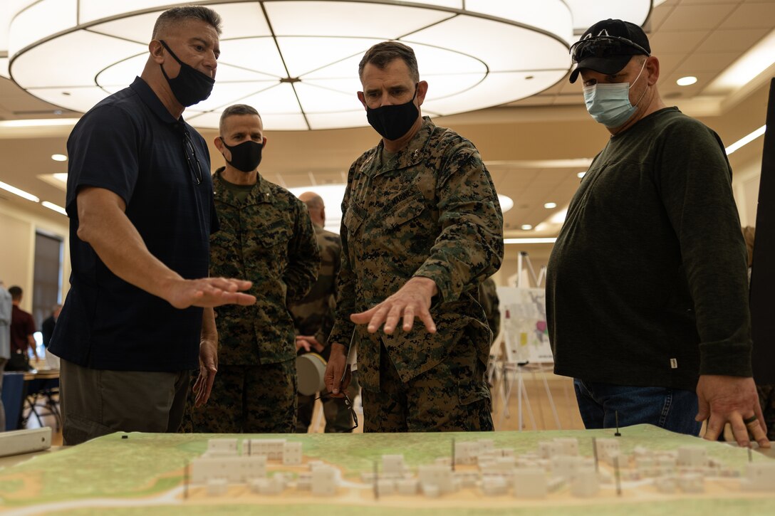 U.S. Marine Corps Maj. Gen. Francis L. Donovan, center right, commanding general of 2d Marine Division, and Brig. Gen. Andrew M. Niebel, center left, commanding general of Marine Corps Installations East-Marine Corps Base Camp Lejeune (MCB Camp Lejeune), examine a MOUT town diorama with warfighter training symposium event hosts at Marston Pavilion, MCB Camp Lejeune, North Carolina, Feb. 28, 2022. The warfighter training symposium educated unit leaders across MCB Camp Lejeune on range modernization efforts, development of new ranges and highlighted other training opportunities and systems available on the installation. (U.S. Marine Corps photo by Lance Cpl. Antonino Mazzamuto)