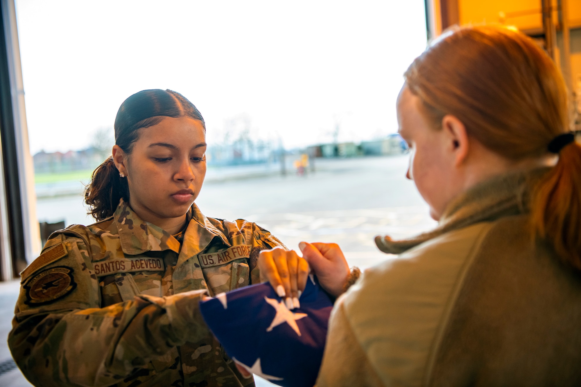 U.S. Air Force Airman 1st Class Jenesi Santos Acevedo, U.S. Air Forces in Europe and Air Forces Africa Air Postal Squadron, Detachment Five mail processing specialist, folds a flag at RAF Alconbury, England, Feb. 9, 2022. Airmen from the 423 Air Base Group honor guard conduct weekly training sessions to hone their skills and build chemistry in executing details with Airmen from different squadrons. (U.S. Air Force photo by Senior Airman Eugene Oliver)