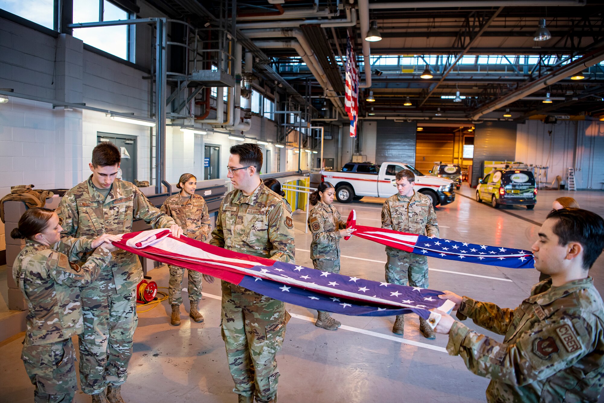 Airmen from the 423rd Air Base Group honor guard, practice flag folding at RAF Alconbury, England, Feb. 9, 2022. Airmen from the 423 Air Base Group honor guard conduct weekly training sessions to hone their skills and build chemistry in executing details with Airmen from different squadrons. (U.S. Air Force photo by Senior Airman Eugene Oliver)