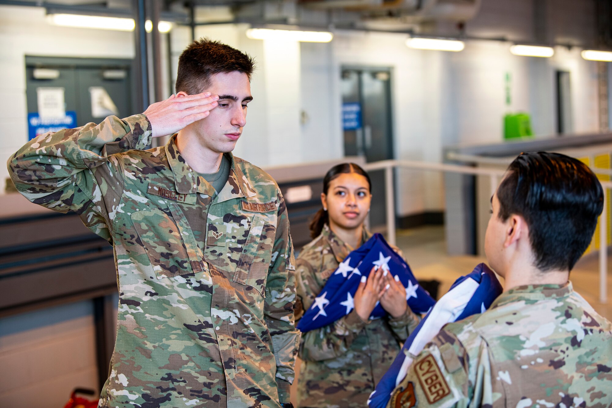 U.S. Air Force Airman 1st Class Jessiah Mosley, 423d Communications Squadron cyber transport technician, salutes after folding a flag at RAF Alconbury, England, Feb. 9, 2022. Airmen from the 423rd Air Base Group honor guard conduct weekly training sessions to hone their skills and build chemistry in executing details with Airmen from different squadrons. (U.S. Air Force photo by Senior Airman Eugene Oliver)