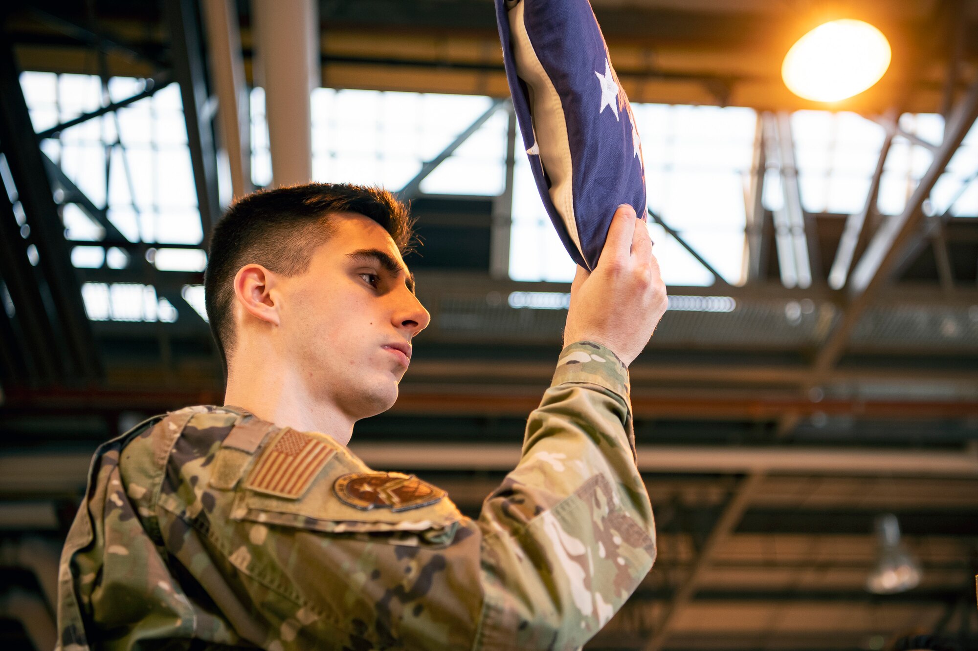 U.S. Air Force Airman 1st Class Jessiah Mosley, 423d Communications Squadron cyber transport technician, holds a folded flag at RAF Alconbury, England, Feb. 9, 2022. Airmen from the 423 Air Base Group honor guard conduct weekly training sessions to hone their skills and build chemistry in executing details with Airmen from different squadrons. (U.S. Air Force photo by Senior Airman Eugene Oliver)