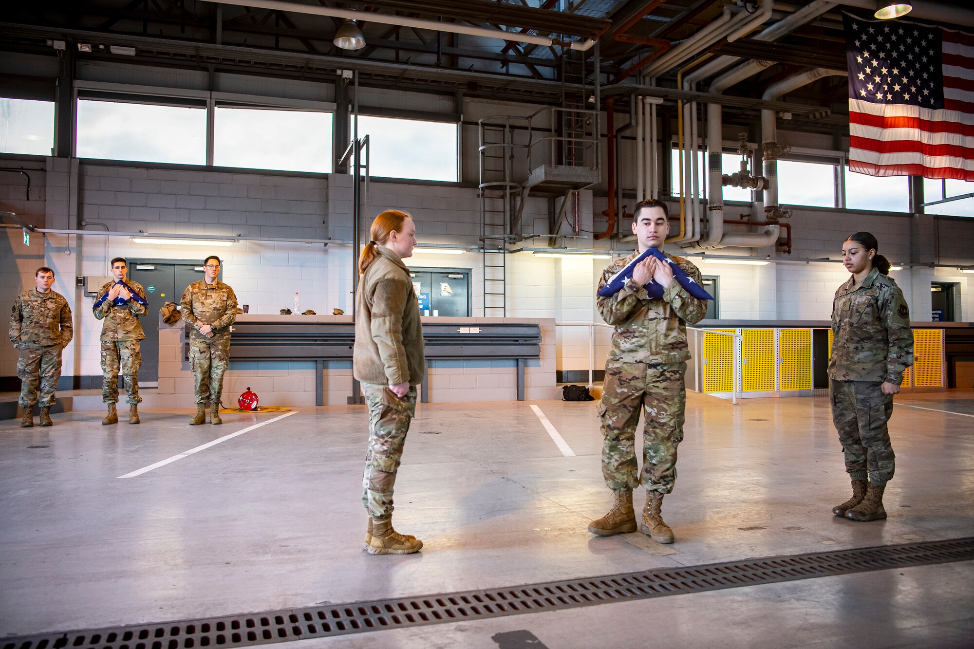 U.S. Air Force Airman Francisco Ruiz, center right, 423rd Communications Squadron client systems apprentice, and Airman 1st Class Alyssa Richmond, center, 423rd Communications Squadron cyber surety apprentice, go through a flag folding sequence at RAF Alconbury, England, Feb. 9, 2022. Airmen from the 423 Air Base Group honor guard conduct weekly training sessions to hone their skills and build chemistry in executing details with Airmen from different squadrons. (U.S. Air Force photo by Senior Airman Eugene Oliver)