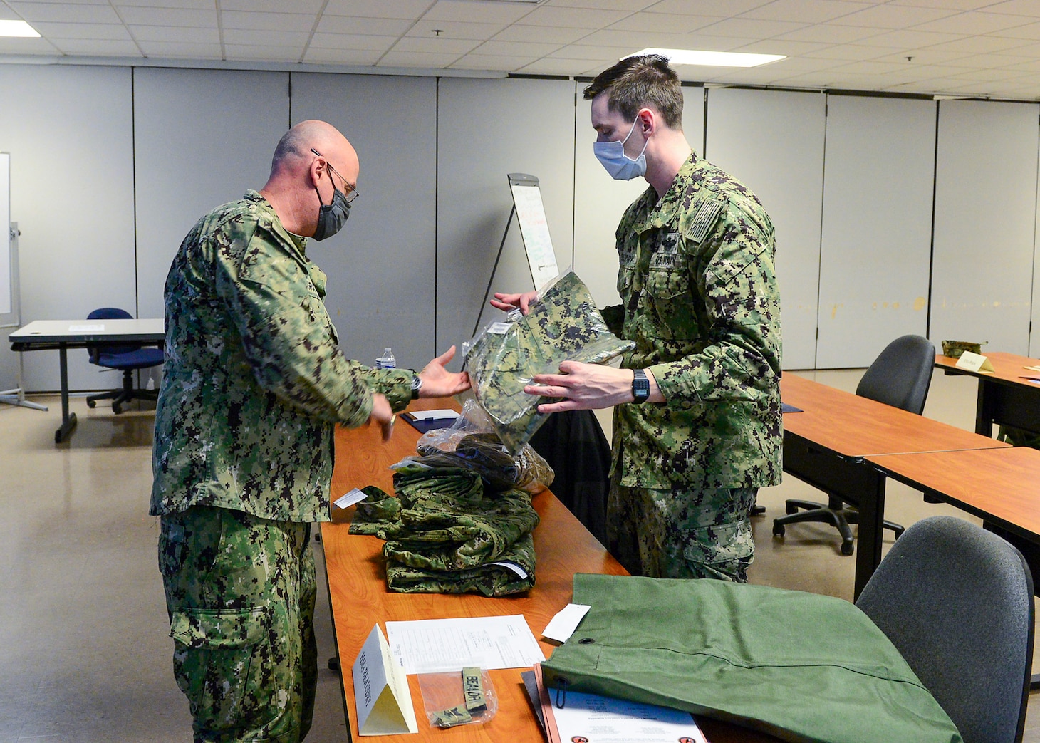 FORT WORTH, Texas (Feb. 16, 2022) - Navy Reserve Region Readiness and Mobilization Command Fort Worth Adaptive Mobilization department staff member Logistics Specialist 1st Class Wilfred Graf, left, issues uniform items to Hospital Corpsman 3rd Class Garrett Beaudry, assigned to Naval Branch Health Clinic San Diego, in preparation for Beaudry’s individual augmentee (IA) assignment to Guantamo Bay, Cuba. IA and mobilization for Selected Reserve processing for Beaudry and other Sailors took place during an adaptive mobilization-enabling event at Navy Reserve Region Readiness and Mobilization Command Fort Worth (REDCOM FW) February 14-18. The event was observed by assessors from Expeditionary Combat Readiness Center, who certified REDCOM FW as a Navy mobilization processing site with delegated Local Area Coordinator for Mobilization (LACMOB) authority. (U.S. Navy photo by Mass Communication Specialist 1st Class Lawrence Davis)