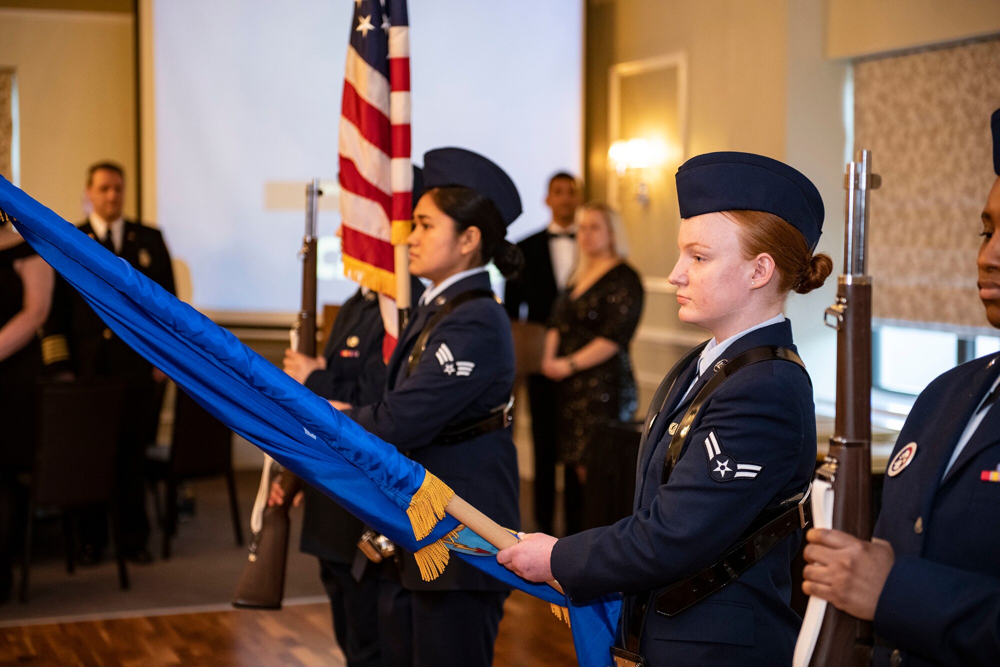 Airman 1st Class Alyssa Richmond, middle right, 423rd Communications Squadron cyber surety apprentice, right, holds the U.S. Air Force flag out during a playing of the national anthem at RAF Alconbury, England, Feb. 25, 2022. Members of the RAFA Honor Guard provided a colors detail in support of the 501st Combat Support Wing Annual Awards ceremony. (U.S. Air Force photo by Senior Airman Jason W. Cochran)