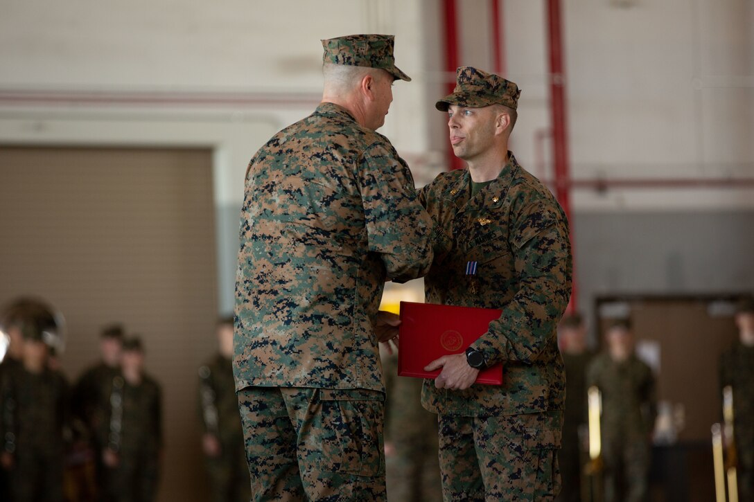 U.S. Marine Corps Maj. Corey Jones, a KC-130J Super Hercules pilot with Fleet Replacement Detachment (right) shakes hand with Maj. Gen. Michael Cederholm, Commanding General of 2nd Marine Aircraft Wing, during an awards ceremony at Marine Corps Air Station Cherry Point, North Carolina, Feb. 28, 2022. Jones, a native of Charlotte, North Carolina, was awarded the Distinguished Flying Cross for conducting an emergency landing after another aircraft collided with his KC-130J Super Hercules. Jones’ piloting skills and timely decisions during the most critical moments of the 12 minutes from mid-air impact to landing are the reasons the entire aircrew were able to walk off the aircraft and are alive today. (U.S. Marine Corps photo by Sgt Servante R. Coba)