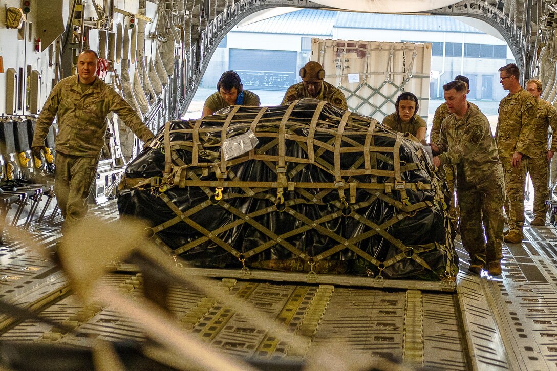 Airmen load cargo on an aircraft.