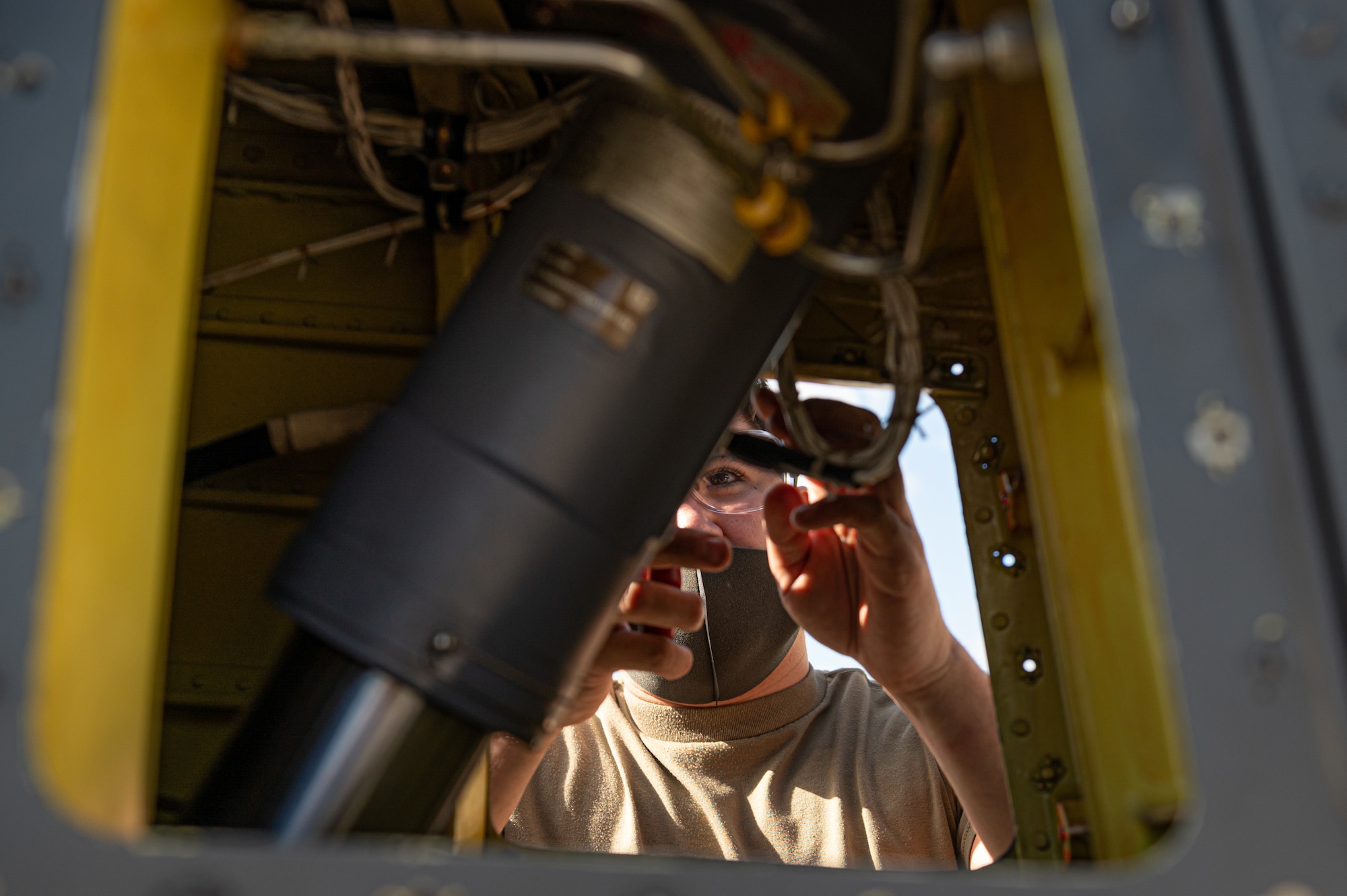 An Airman performing maintenance on a helicopter