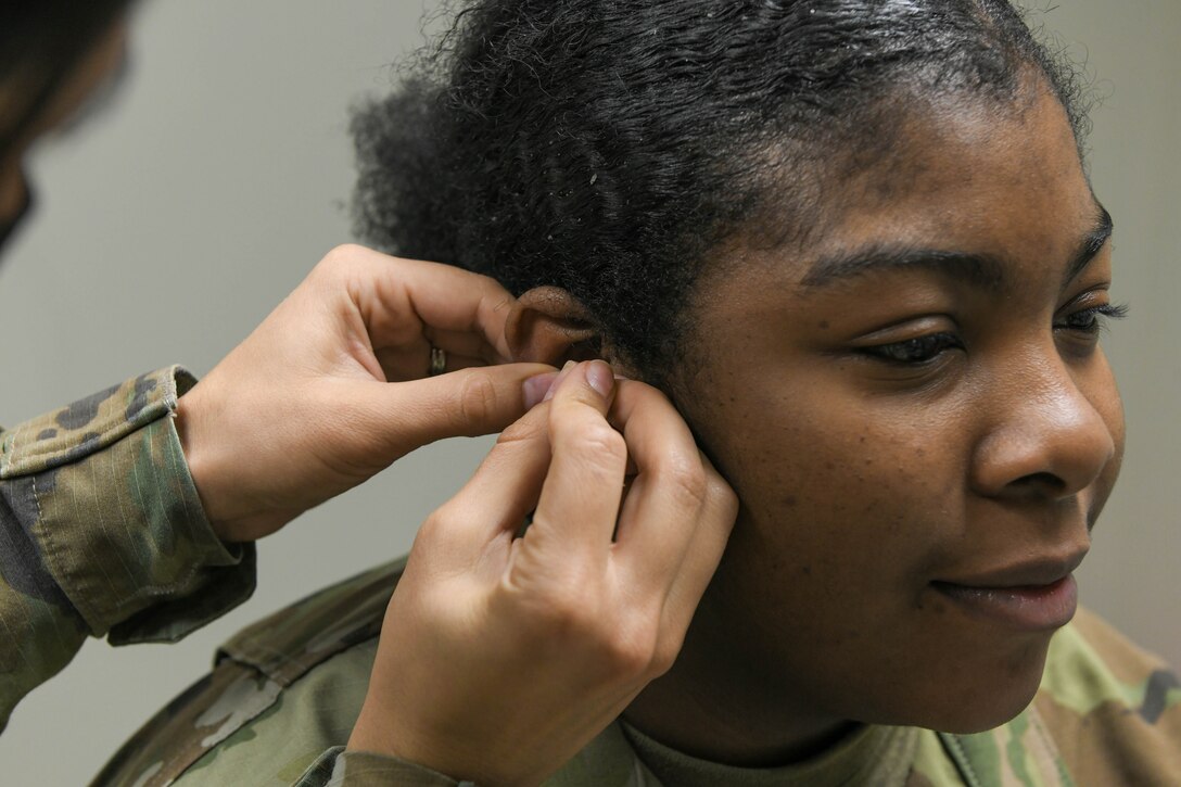 Dr. Jessica Gamboa, 97th Medical Group chief of medical staff, performs battlefield acupuncture on Senior Airman Alexzandria Body, 97th Operational Medical Readiness Squadron pediatric and family health front desk clerk, at Altus Air Force Base (AFB), Oklahoma, Feb. 10, 2022. The new services are focused on improving care for Airmen and their families, as well as cultivating an environment of excellence at Altus AFB. (U.S. Air Force photo by Airman 1st Class Trenton Jancze)