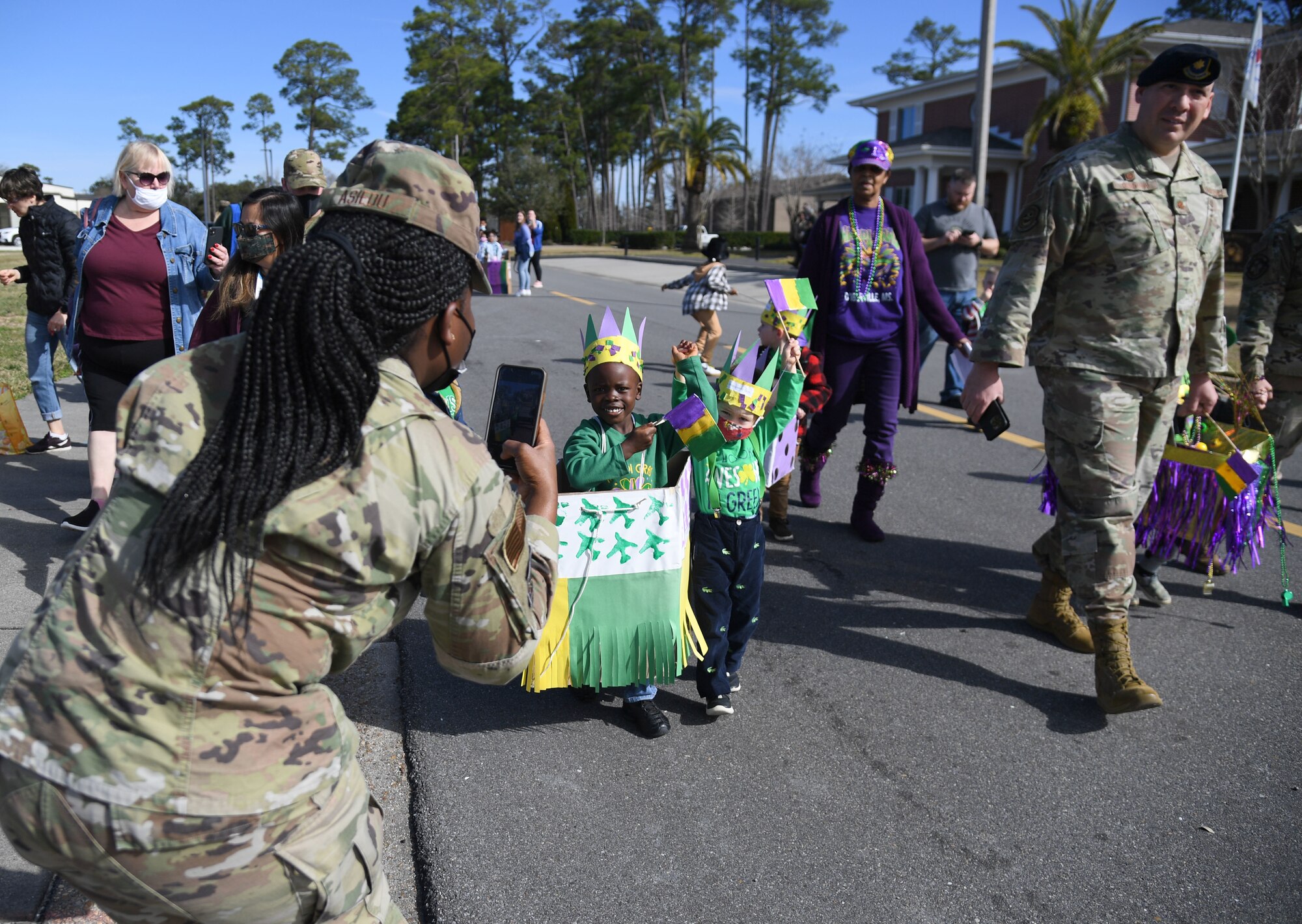 The Keesler Child Development Center celebrates Mardi Gras with a parade at Keesler Air Force Base, Mississippi, March 1, 2022. Family members line the street to watch their children parade by them while wearing festive clothing, beads and make-shift floats. (U.S. Air Force photo by Kemberly Groue)