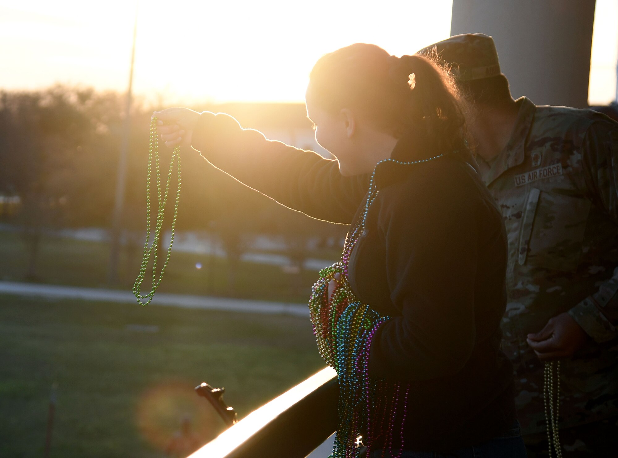 U.S. Air Force Airman 1st Class Emily Marshall, 335th Training Squadron student, prepares to toss strands of beads to 81st Training Group Airmen behind the Levitow Training Support Facility at Keesler Air Force Base, Mississippi, March 1, 2022. The event, hosted by the 81st Training Wing chaplains office, was in celebration of Mardi Gras and also provided gumbo and king cake. (U.S. Air Force photo by Kemberly Groue)