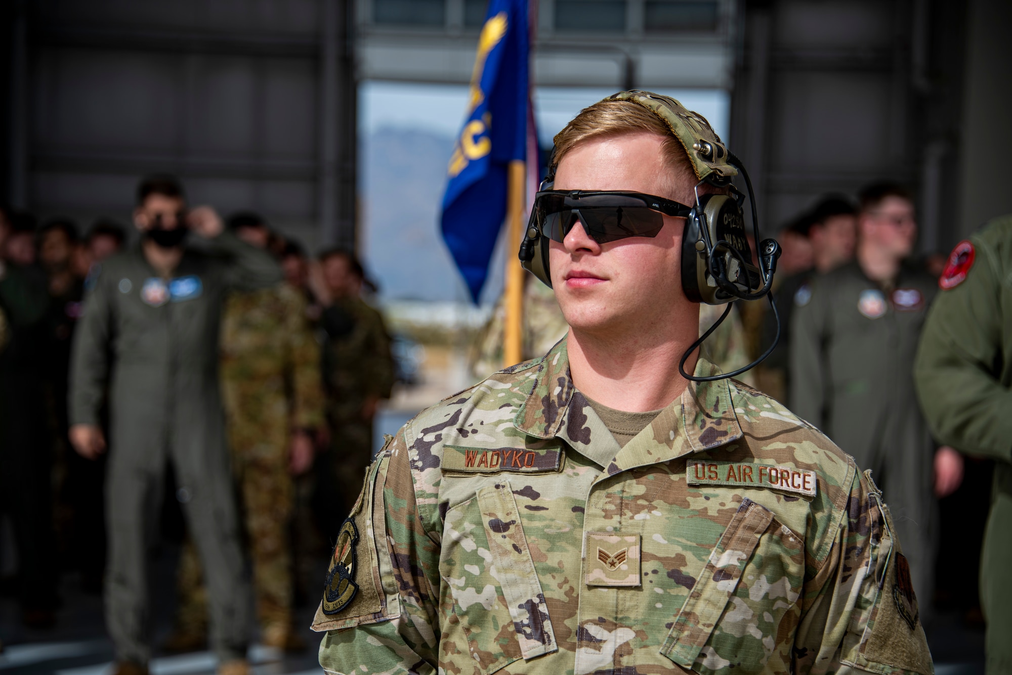 A person wearing sunglasses stares off in the distance.